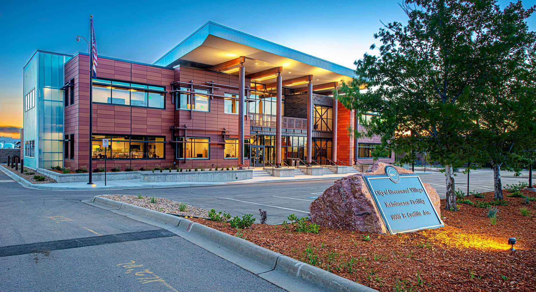 Exterior of the Greenwood Village Maintenance Facility designed by D2C Architects. There is a plaque out front and it is dusk.