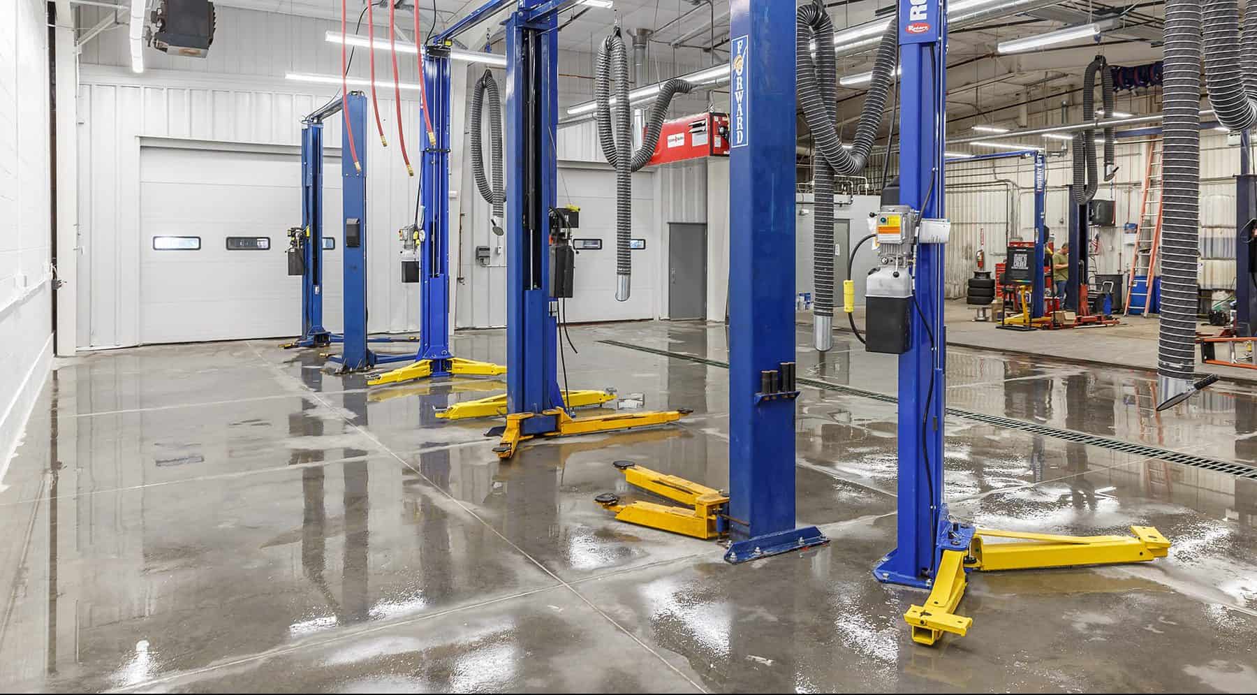 Service bay with blue metal columns. The floor is reflective of the lights above