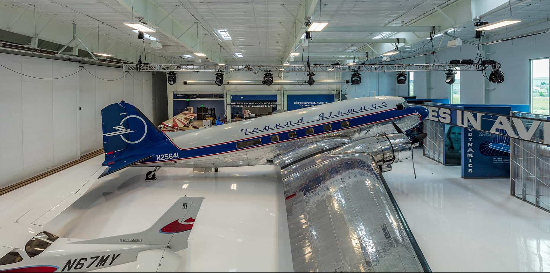 Large plane sitting in the bright, white room of the Wings over the Rockies, Blue Sky Gallery