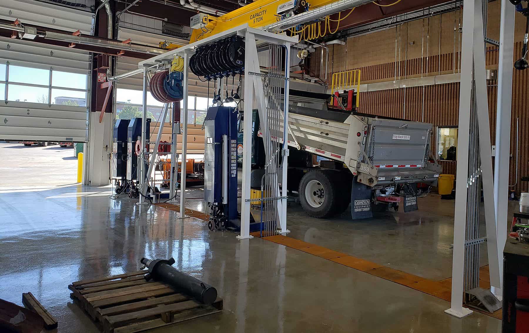 The backside of a service truck undergoing maintenance in a service bay. The door is slightly open.
