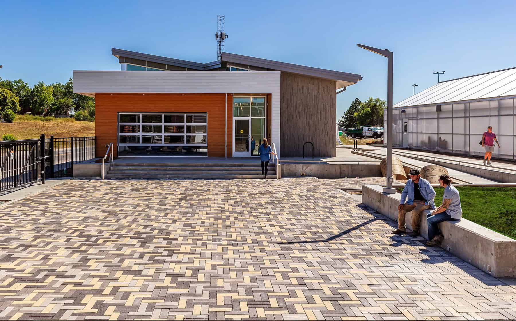 The courtyard and exterior of the Westminster Greenhouse and Administration Center, the roof is has a green roof system that has started to seed.