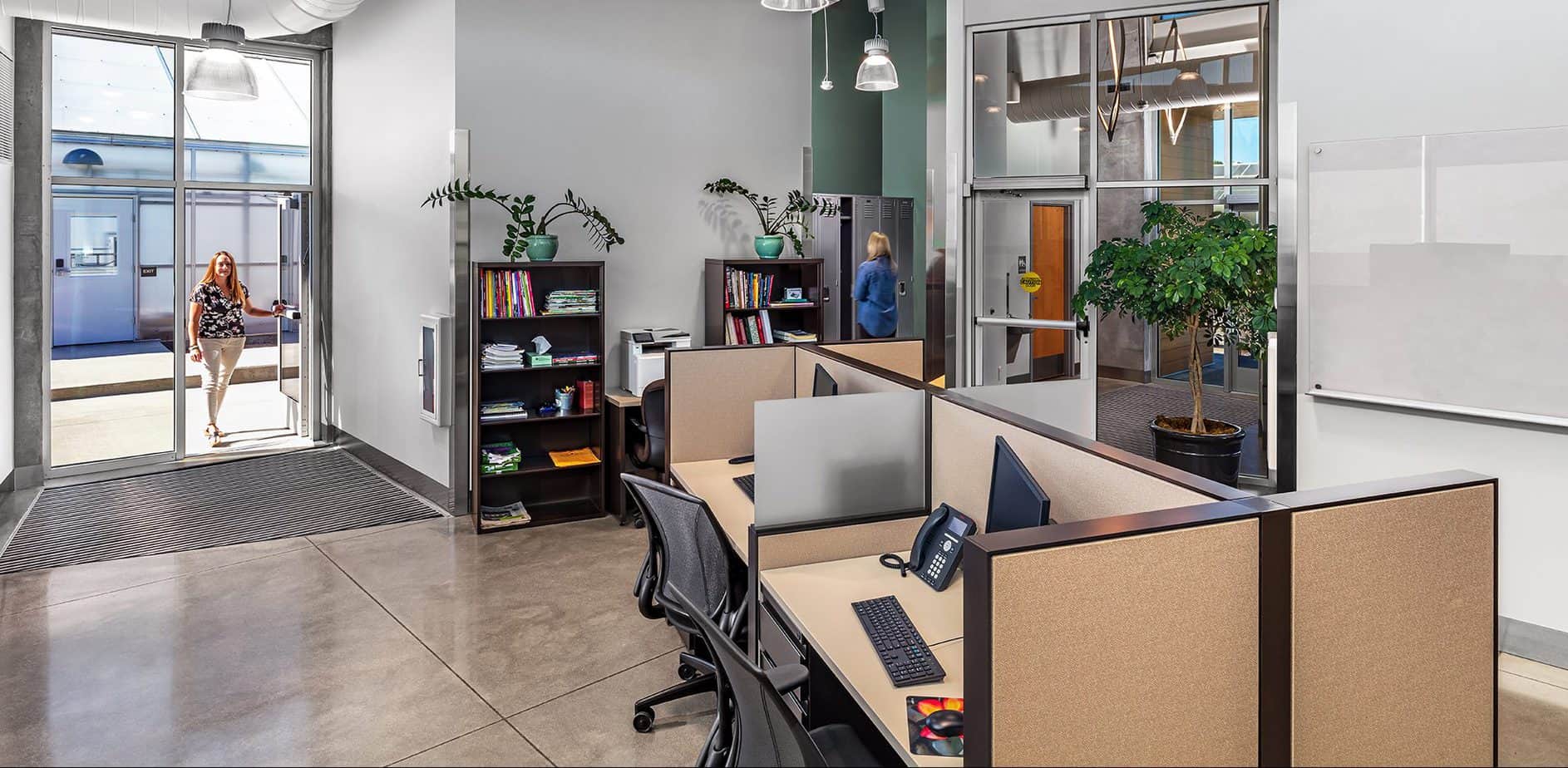 Office space with desks, monitors, chairs and bookshelves